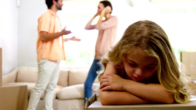愤怒的父母在一个悲伤的女孩背后争吵