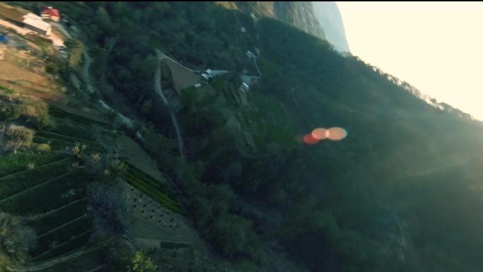 飞机在山丘上方美丽的山村里快速俯冲