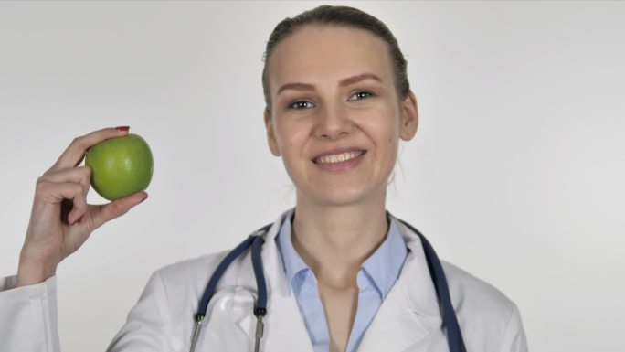 女医生展示绿苹果，健康护理
