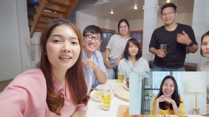 一群年轻人在家里的晚宴上与朋友远程视频