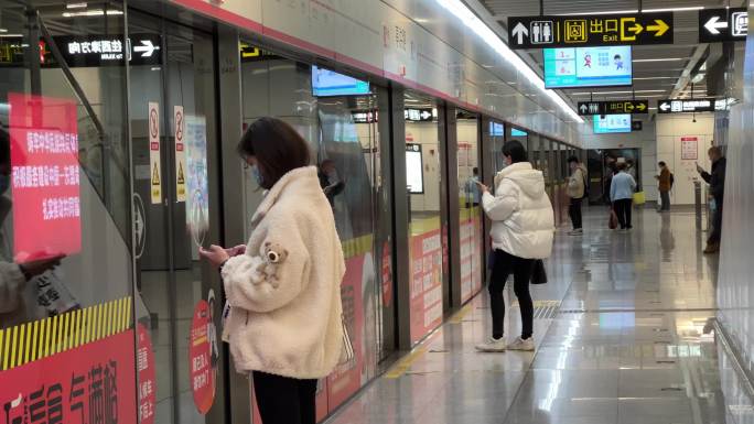 地铁站里等车的美女手机族沉浸式玩手机