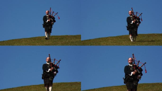 身着传统苏格兰服装的风笛手在山顶上演奏