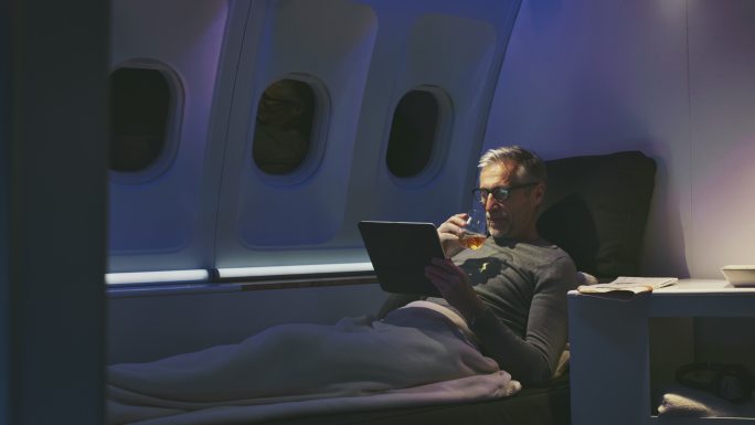 男性在飞机上使用数字平板电脑