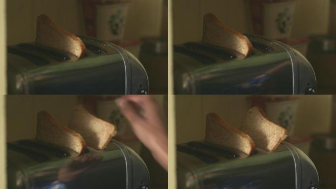 一名妇女将切片面包放入烤面包机