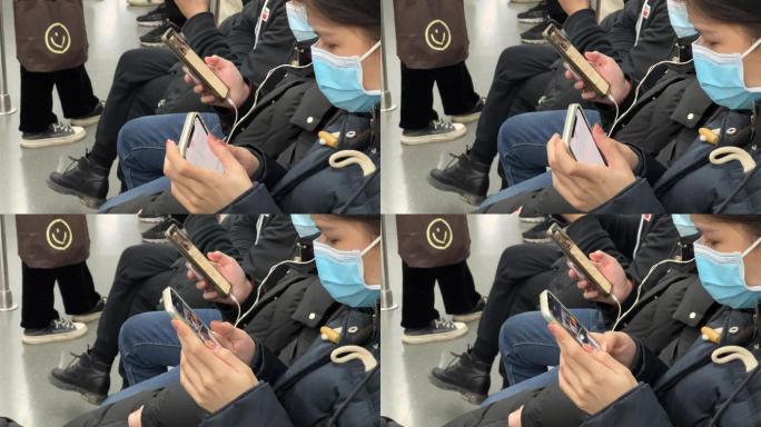 地铁上低头族戴着口罩沉浸式玩手机的年轻人