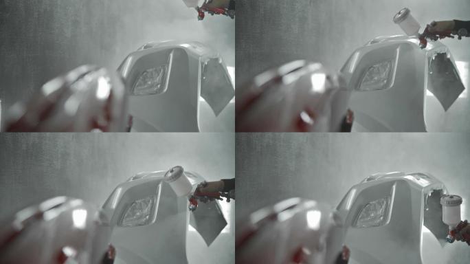 男工人使用喷雾压缩机对汽车零件喷漆