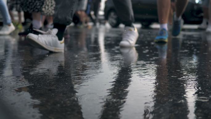 雨中人群在拥挤的交通道路上行走