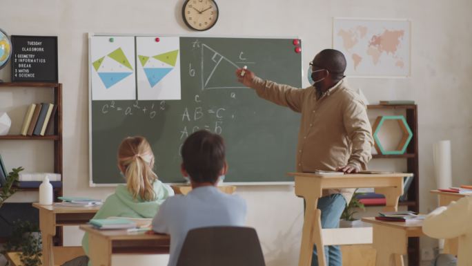 戴口罩的男教师给小学生上课