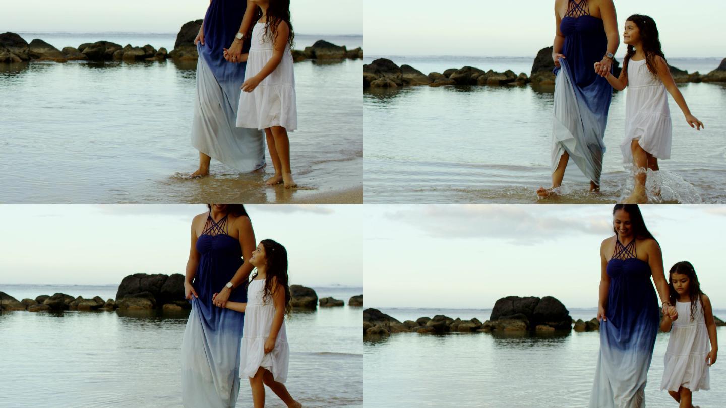 母亲和女儿穿着夏装在热带气候的沙滩上玩耍
