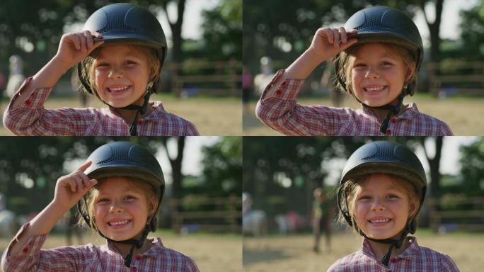 一个戴着头盔的小女孩在马厩里微笑