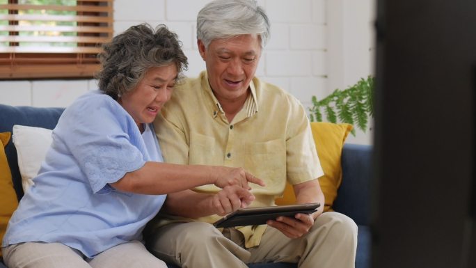 亚洲老年夫妇使用平板电脑搜索网上购物