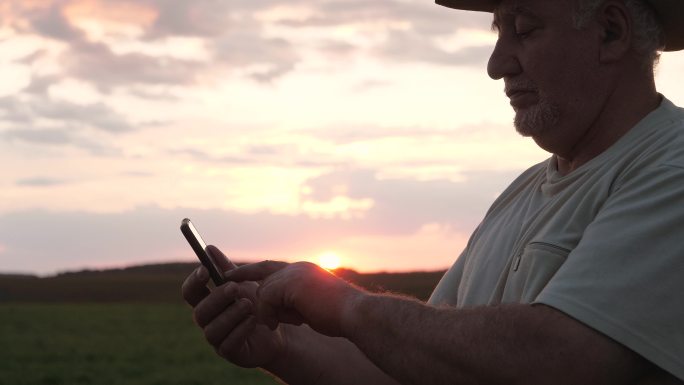 男子在田野里用智能手机