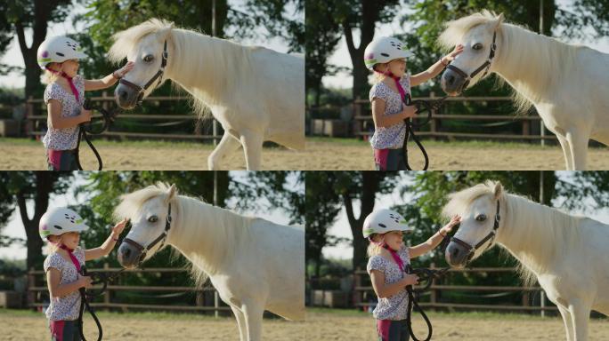 小女孩在马厩里爱抚一匹白色小马