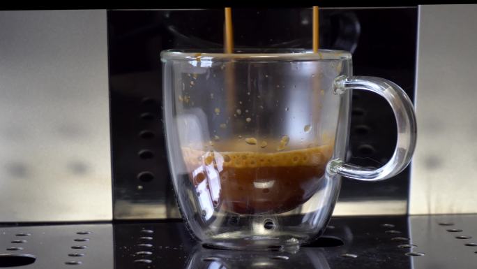 咖啡机在杯子里装满热咖啡