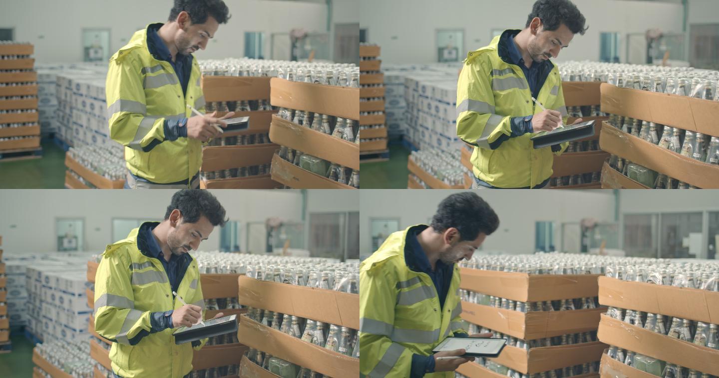 男工人在一家装瓶厂检查饮料产品的库存
