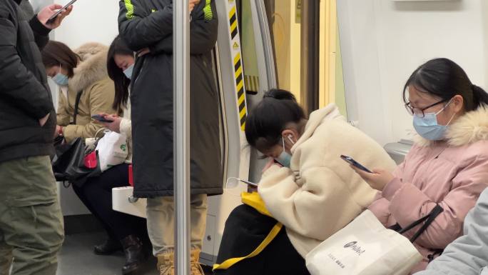 地铁列车车厢里的低头族沉浸式玩手机
