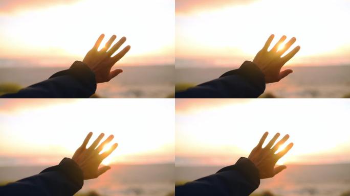 一个人举起手挡着太阳