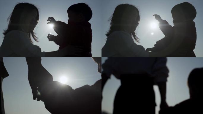 母亲和孩子拥抱大手牵小手温情视频逆光剪影