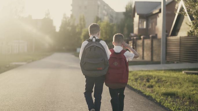 两个小学生放学后回家，他们聊天。