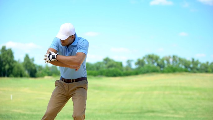 男性穿着运动服打高尔夫