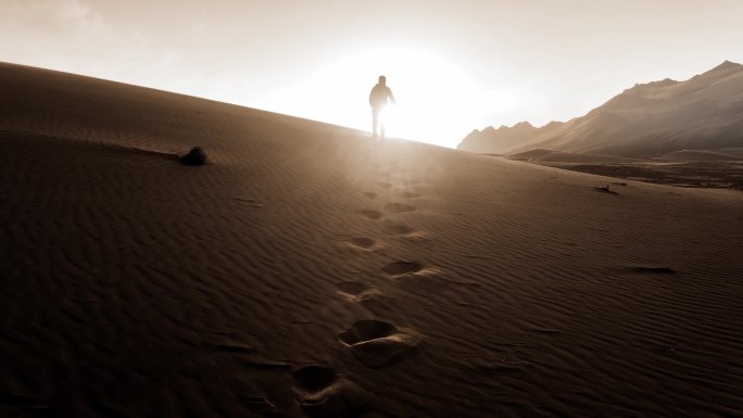 逆光人在沙漠中行走