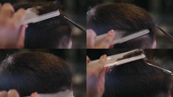 美发师用剪刀和梳子做发型。