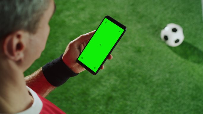 足球运动员手持智能手机