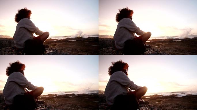 夕阳下独自一人坐在海滩上沉思的少年