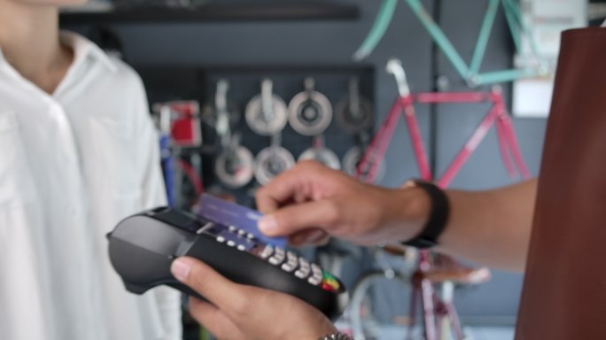 顾客用信用卡支付在自行车店购买的物品