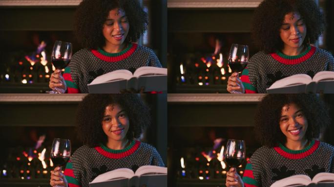 一名年轻女子在家休息时看书喝酒