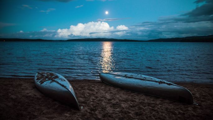 月光下湖边的两艘独木舟