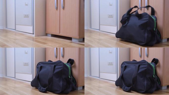 把一个旅行袋扔到房间角落里。