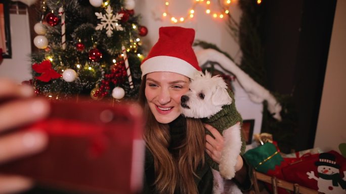 圣诞节期间，女子在家里和她的狗自拍