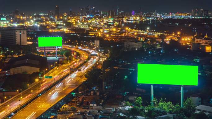 夜间道路上的绿色屏幕广告牌