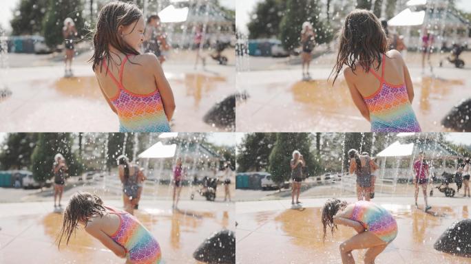 小女孩在水上公园的喷泉里玩耍