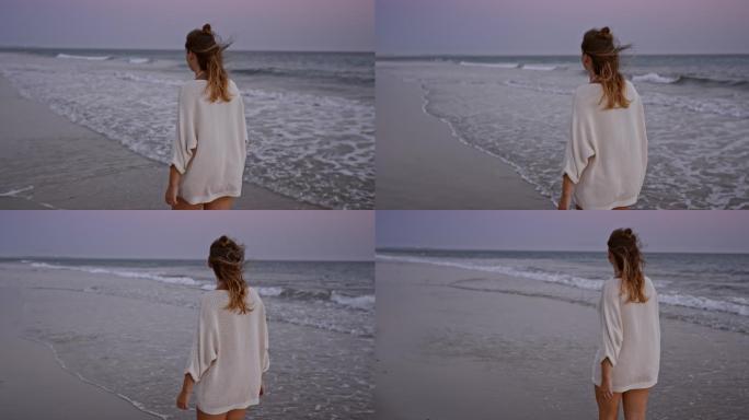 日落时独自在海滩上散步的女人