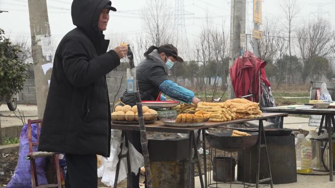 油条摊位老人吃油条