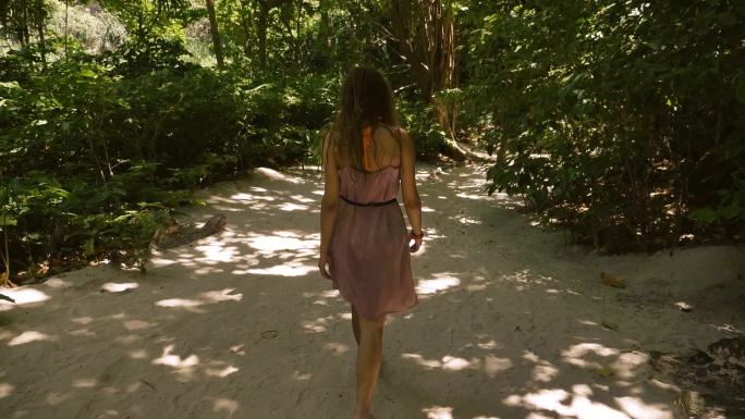 缓慢地走进热带森林的女孩。
