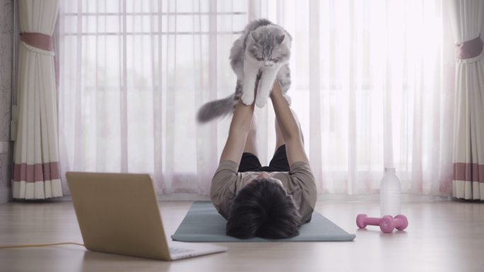 年轻人和他的猫在家锻炼