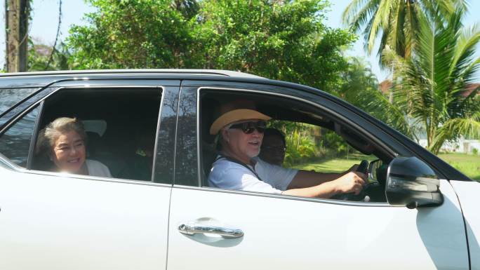 男子在海滩公路旅行中开车与家人交谈