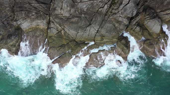 岩石海滩上的海浪浪花峭壁