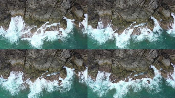 岩石海滩上的海浪浪花峭壁
