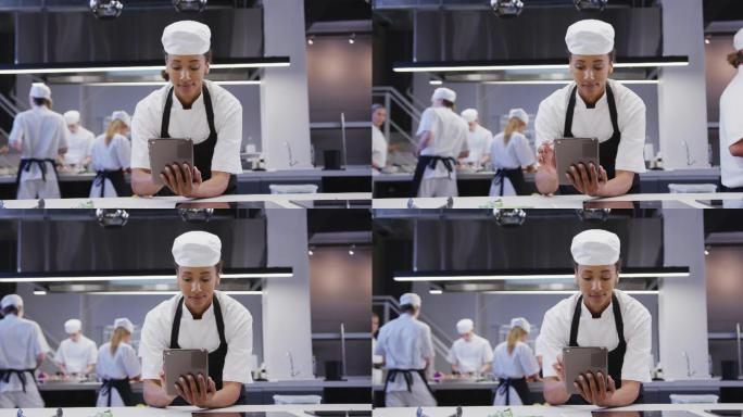女厨师在餐厅厨房使用平板电脑