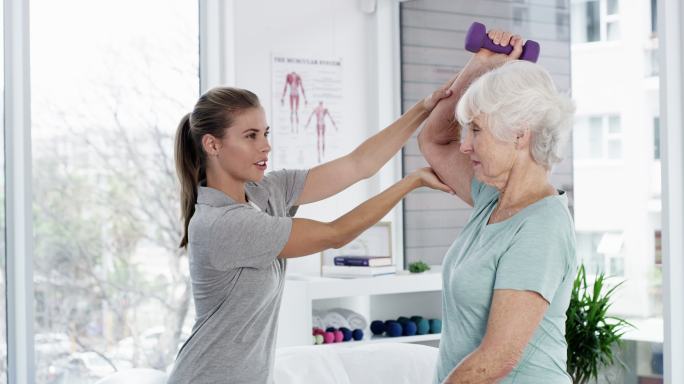 护士帮助老年患者进行锻炼