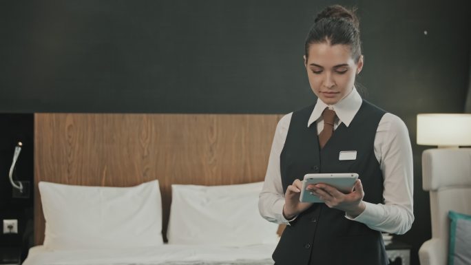酒店房间内手持平板电脑的女经理