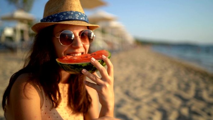 在海滩上吃西瓜的女人