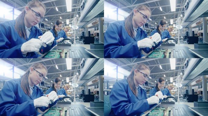 电子工厂女工人正在用螺丝刀组装笔记本电脑
