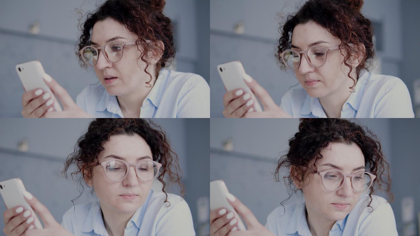 戴眼镜的悲伤女人手持智能手机