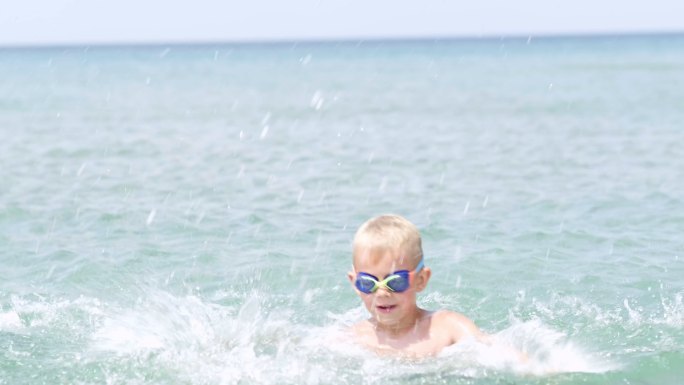 快乐微笑的小男孩在海水中玩耍