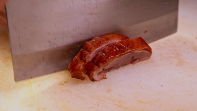 广东烧卤店的师傅在切烧鸭，装盘做烧鸭饭